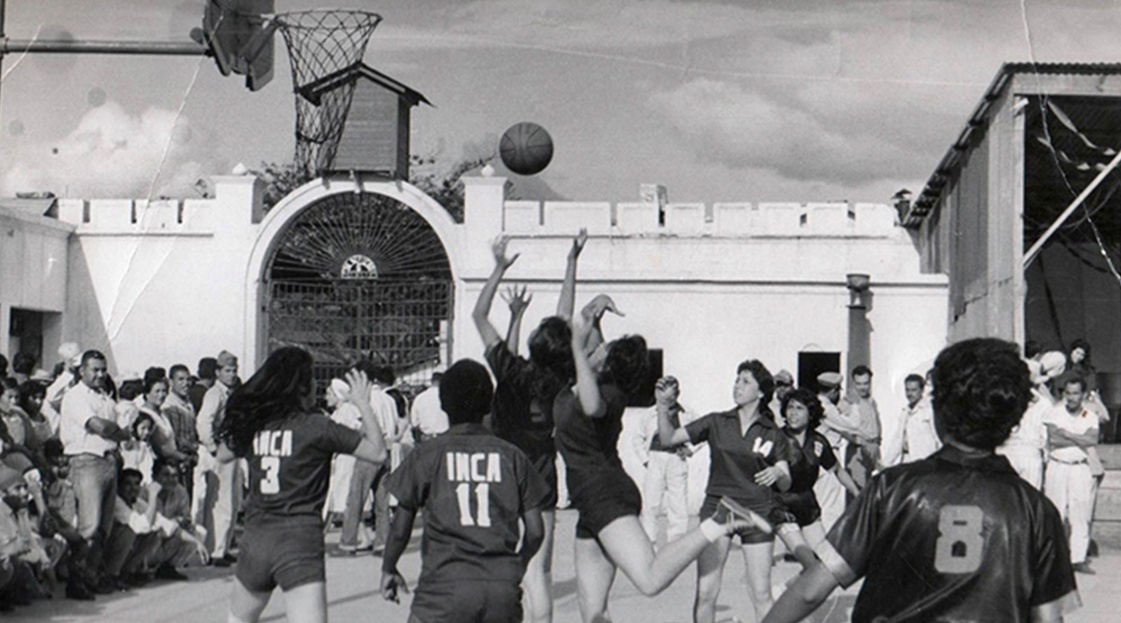 Grupo de jóvenes jugando baloncesto en la década de 1960.